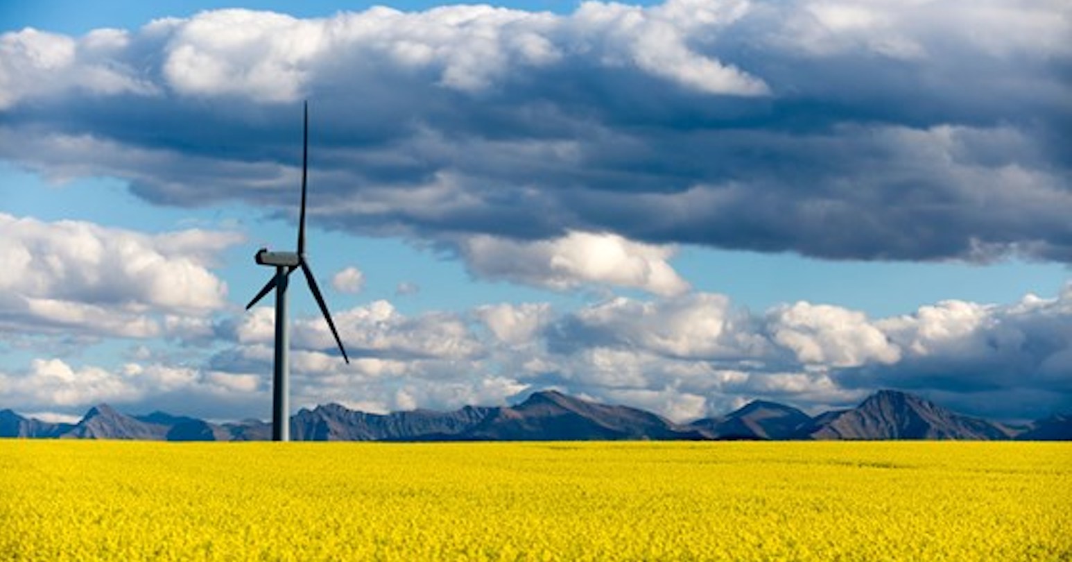 Skyline with mountains, wind turbine, and clouds