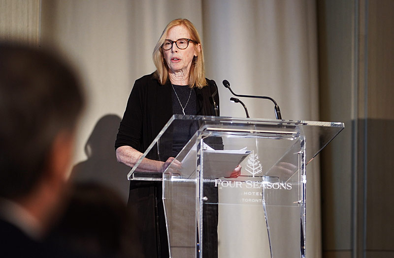 Mary Crossan at a podium speaking at an event