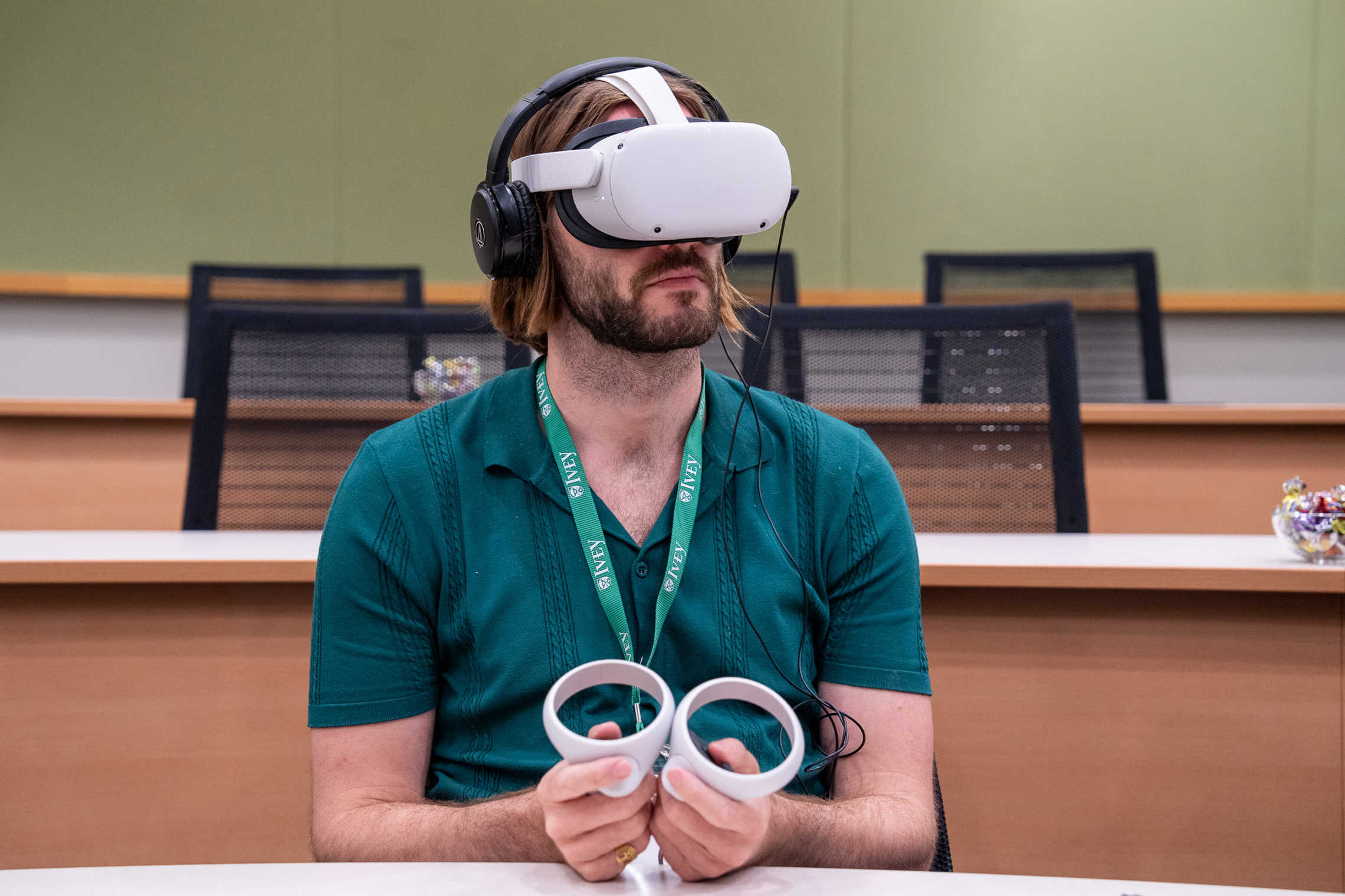 A male student wearing a VR headset in a classroom.