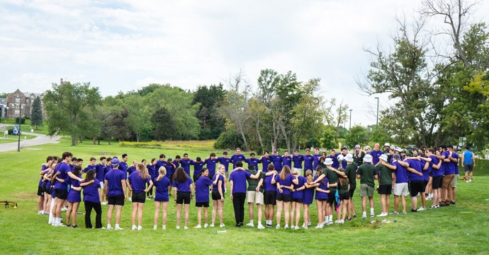 HBA students standing in a circle with their arms around each other