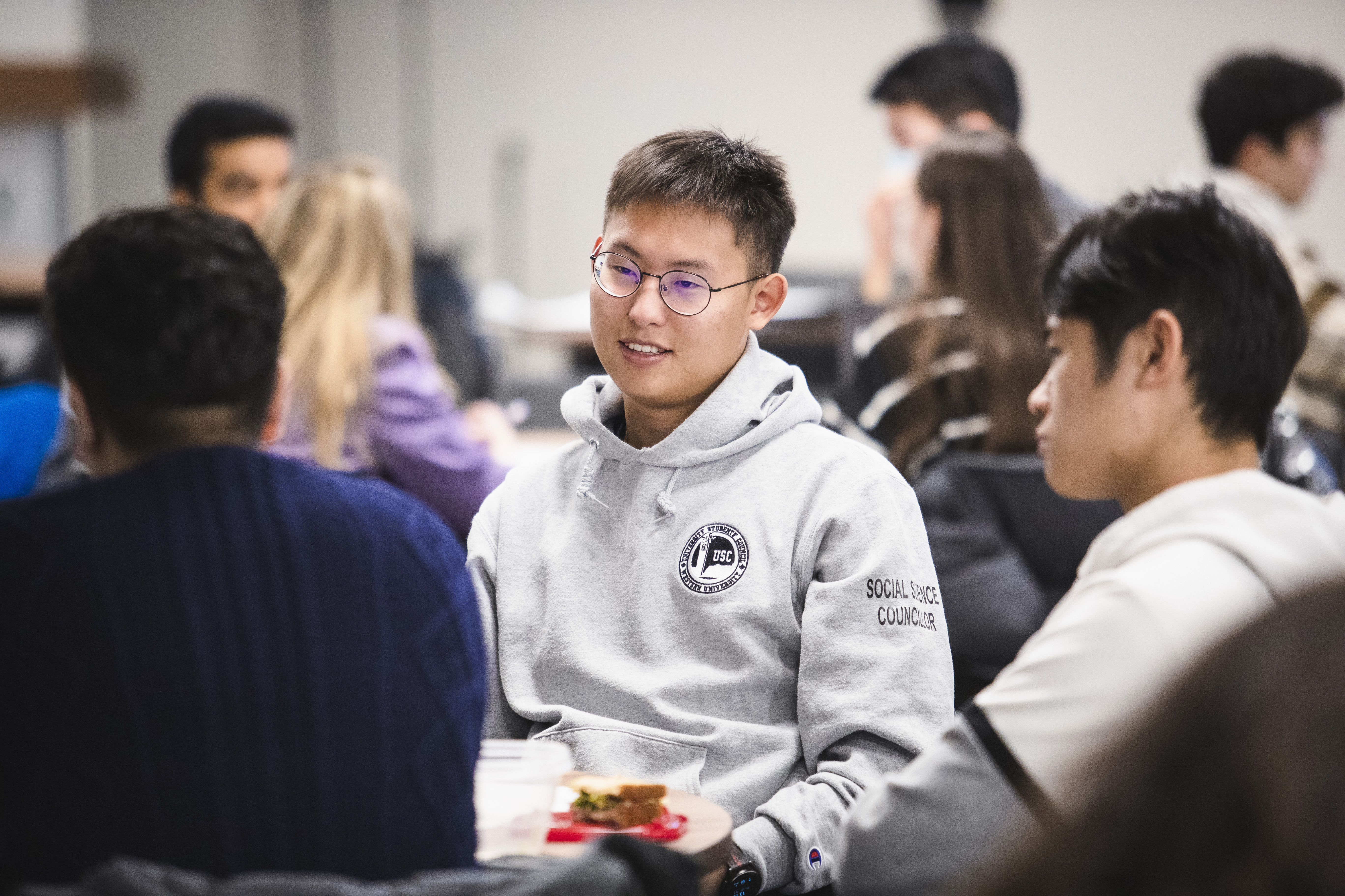 Looking Forward Three Students Sitting Around Table