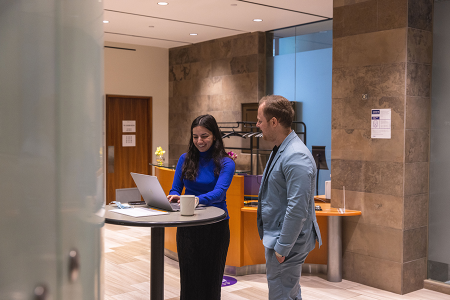 Students looking at a laptop in an Ivey meeting room